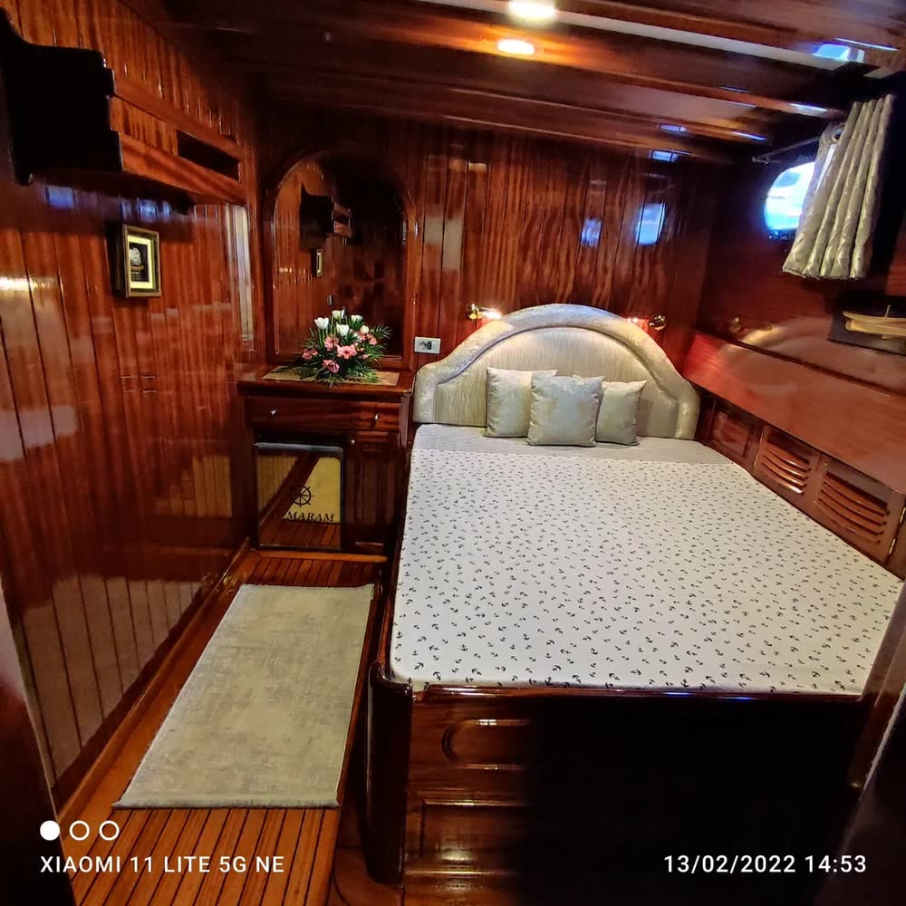 Cabina matrimoniale in mogano, con i fiori sul comodino