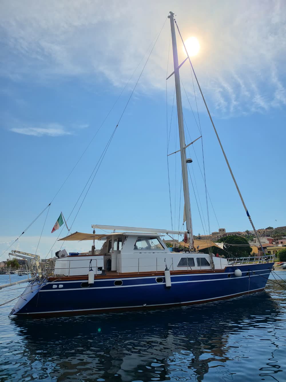 La barca da venti metri ormeggiata, scafo blu e tuga bianca