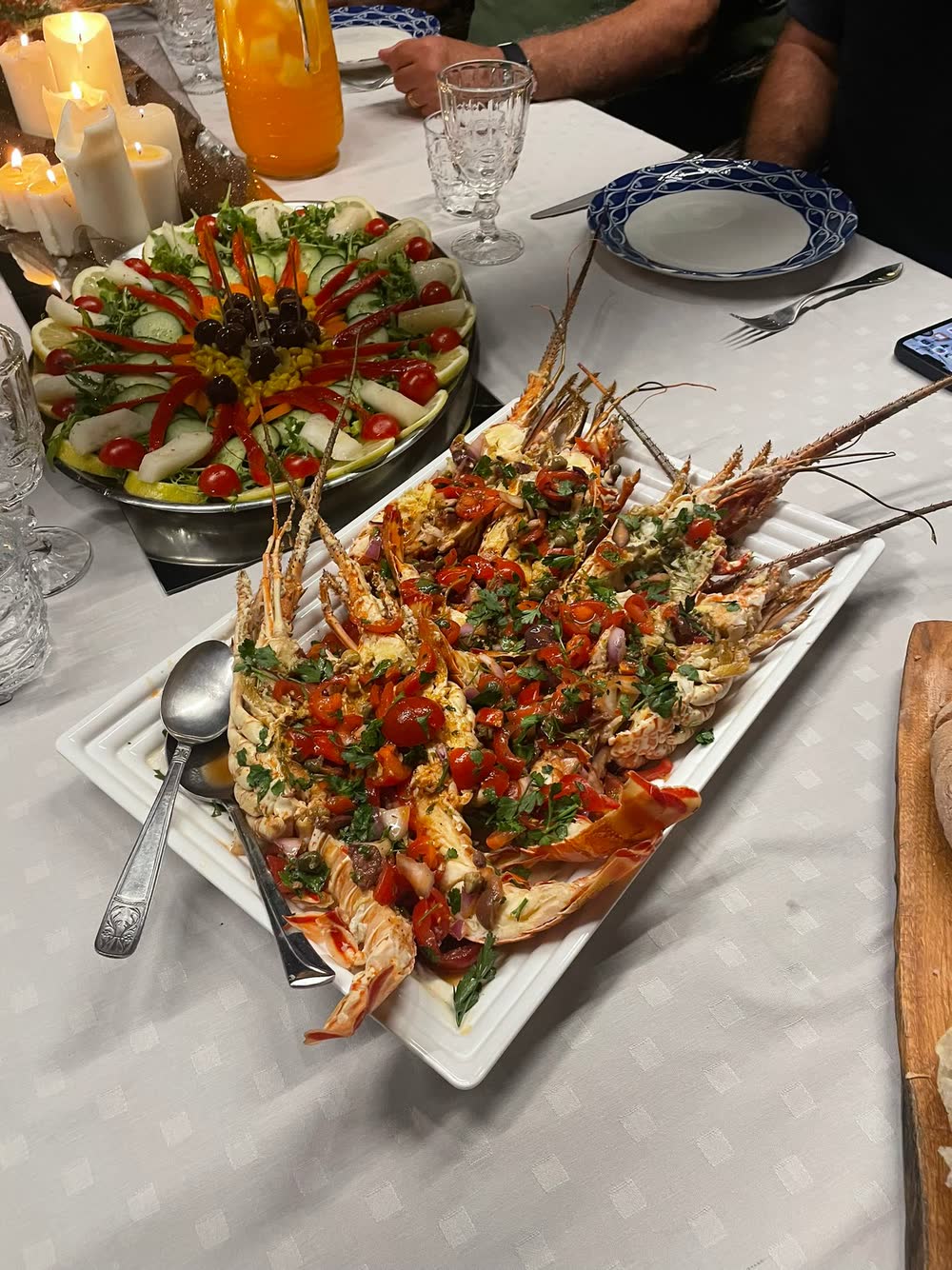 Tavola a lume di candela con aragoste e verdure